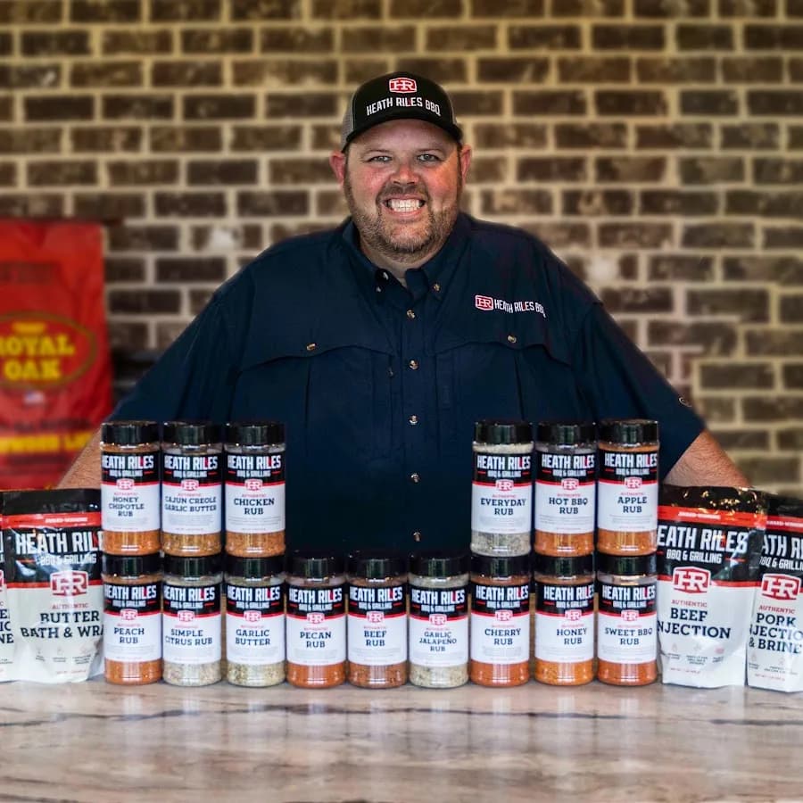 Heath Riles behind a full table of his BBQ rubs, injections and brines.