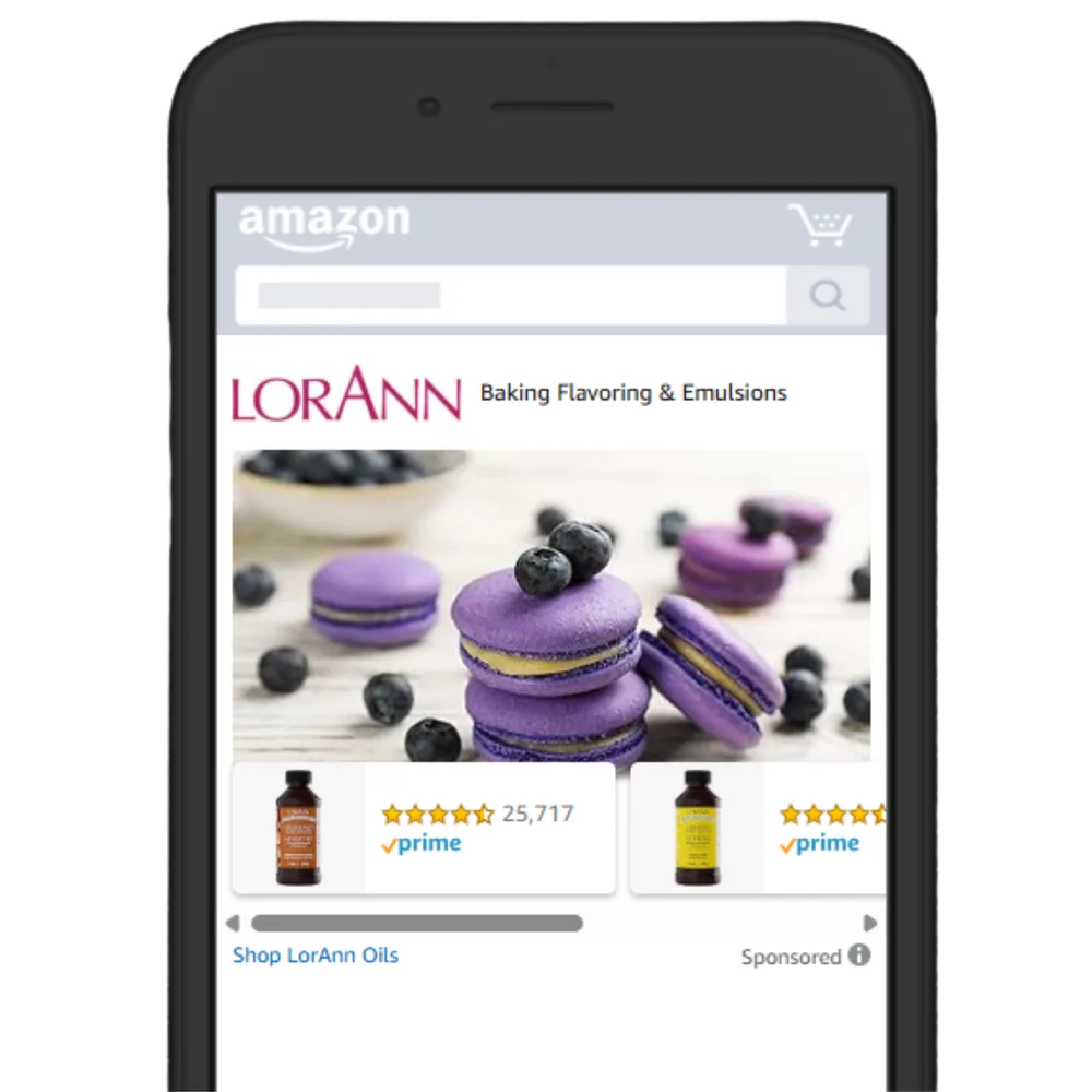 A LorAnn Oils Sponsored Brands ad on the Amazon mobile app, showing blueberry macarons above two flavouring bottles.